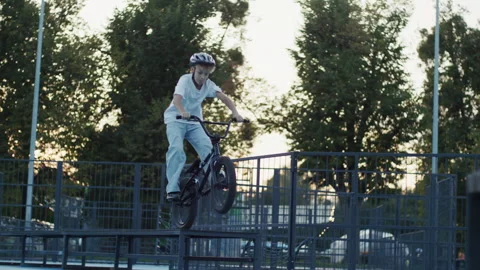 10 Year Old Boy Performing Bunny Hop Jump on BMX Bicycle in Skate Park Video stock 346156846