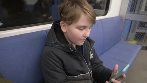 A 10-year-old boy rides the subway and plays on a smartphone Stock-Footage 249265643