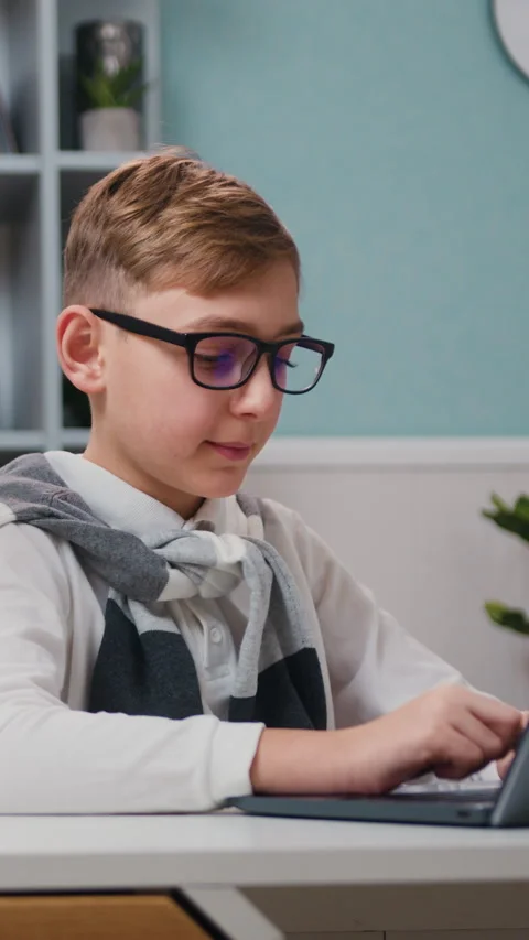 10 Year old boy typing on laptop keyboard during online lesson, distance studyin Stock Footage 329886705