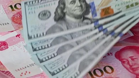 100 american dollar banknotes are placed on top of Chinese yuan bills Stock Footage 336663708
