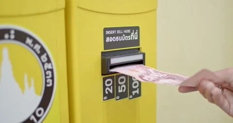 A 100 baht banknote is inserted into a coin changer. Stock Footage 222582838
