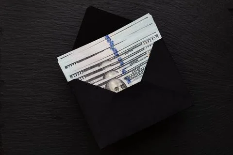 100 dollar bamknote in handmade envelope on black background Stock Photos