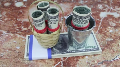 100 dollar banknotes in a small bucket and basket on a bundle of bills. Vídeos de archivo 147020999