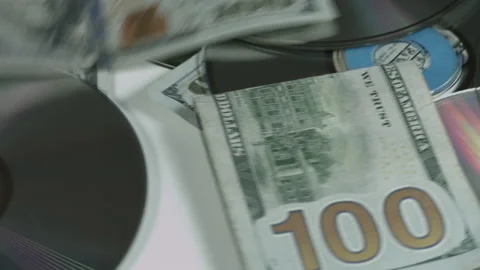 100 Dollar Bills and CDs Slowly Rotate On White Background 4K Stock Footage 217633334
