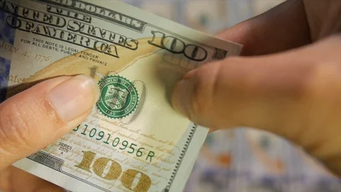 A 100-dollar US bill being inspected closely to verify its authenticity Vídeo Stock 105187882