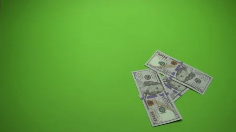 100 dollars notes is falling into green background. Slow motion 120fps Stock Footage 85395439