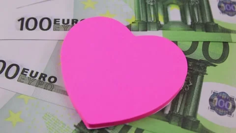 100 euro banknotes rotating on a table with multi-colored heart-shaped stickers Vídeo Stock 142029959