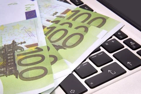 100 euro bills lying on a computer keyboard, close-up Stock Photos