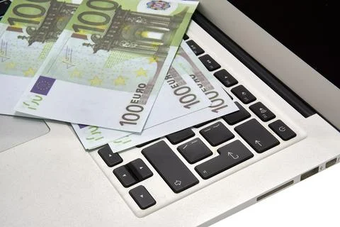 100 euro bills lying on a computer keyboard, close-up Stock Photos