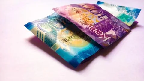 100 Kenya Banknote Folded on 2 Others on white Stock Photos