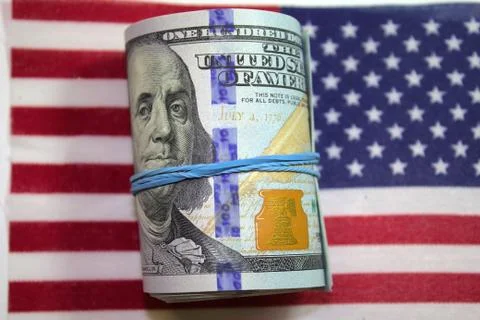 100 US dollar banknotes roll on United stated of America or USA flag Stock Photos