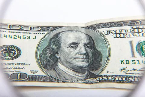 100 US Dollar banknotes under magnifying glass. The concept of business: hund Stock Photos