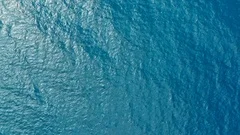 aerial drone footage of the deep blue clear sea ocean water with small waves