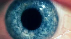 Blue eye pupil zoom in futuristic space burst