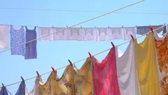 CLOSE UP: Colorful sheets, clothes, and towels are hung to dry in summer air.