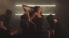 Sexy men in masks and woman in black dance