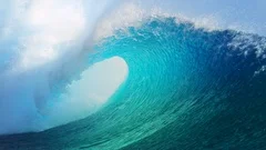 SLOW MOTION: Forceful barrel wave splashes water around the coast of Tahiti.