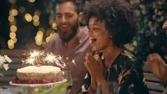 friends celebrating birthday party dinner surprising friend with cake happy