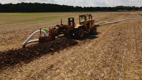 11-06-2022 Large machine expertly lays pipes in a sprawling field. Stock Footage 259326570