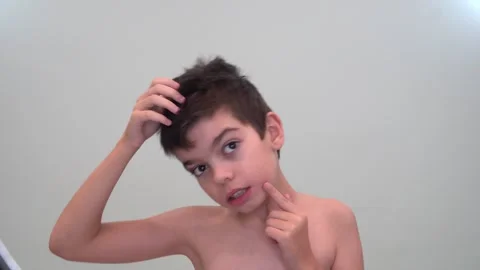 11 boy examining his forehead, brunette, brown eyes Video stock 268429647