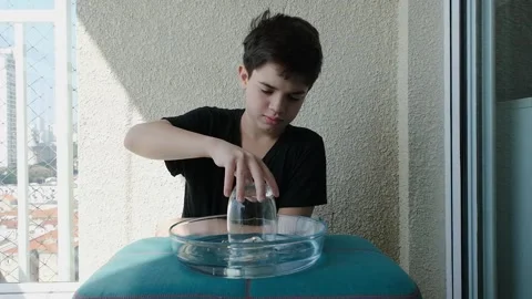 11 year old boy doing an experiment on the difference between atmospheric p.. Stock Footage 280929800