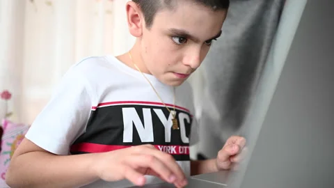 11 year old boy studying at home with the help of his mother Stock Footage 130335674