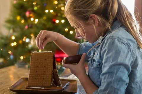 11 year old girl building a ginger bread house at home Stock Photos