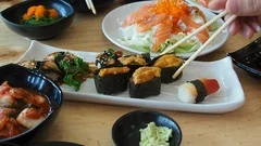 Man using chopsticks for eating sushi in japanese food restaurant.