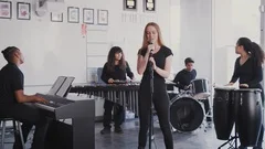 Students At Performing Arts School Playing In Band At Rehearsal