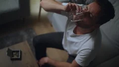 Man alcoholic drinking alcohol from glass at home