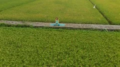 Slowmotion aerial shot of a young woman doing meditation for Muladhara chakra in
