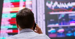 4K View from behind of financial trader dealing over the phone in stock exchange