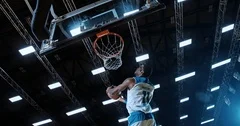 Professional basketball player in action performing slam dunk