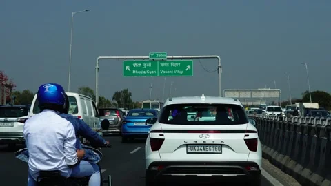 12-03-24; Directional board overhead vehicles moving below on road in Gurugram. Stock Footage 271372211