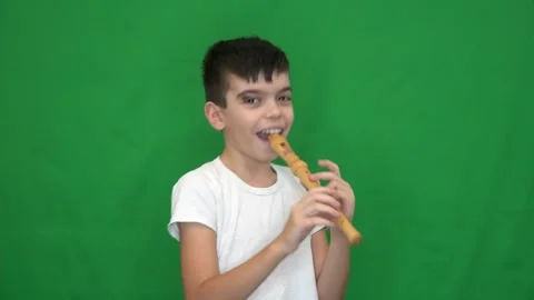 12 brunette boy in a white jacket plays the recorder Stock Footage 266450641
