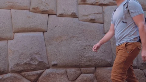 12 sided Inca Angle Wall Stone located at Cusco in Peru. Man passing by. Stock Footage 91401590