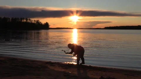 12. At sunset, a boy plays with sand Stock Footage 133434734