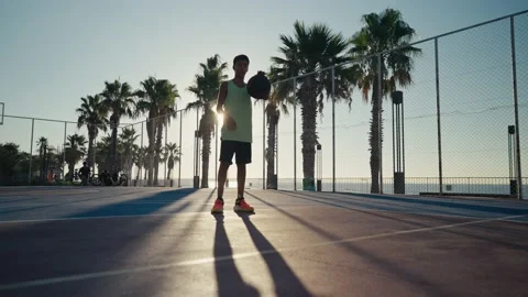 12 year old boy bouncing basketball ball training on ground floor of the court 스톡 동영상 208167950