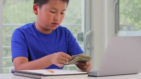 12 year old boy keeping track of his allowance Stockbeeldmateriaal 252236128