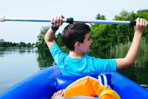 12 year old boy lying in canoe on Lake Monate Foto stock