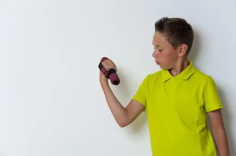 12 years old boy doing biceps exercise, copyspace Stock Photos