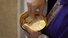 Giving Holy Communion in church, close-up of hands