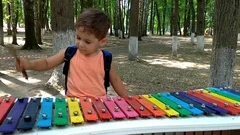 At a city festival, children play children's musical instruments.