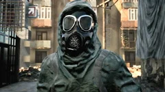 A stray man in military protective clothing and a gas mask is walking through