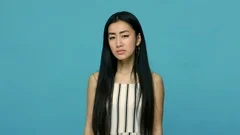 I can't hear you! Attentive asian woman with long straight black hair in dress