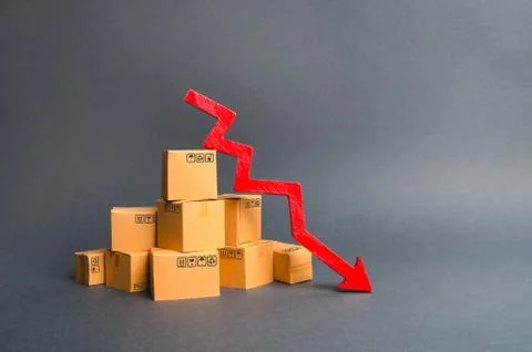 A pile of cardboard boxes and a red arrow down. The decline in the ...