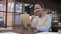 African Woman Celebrating Success on Tablet PC