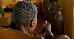 Elderly senior black woman rubbing her joints of her hands to relieve pain
