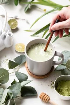 A  vertical  shot  of  Green  tea  latte  with  milk  in  a  white  cup  with  green  leaves  and  wooden  spoon xkwx tea,  green,  latte,  drink,  cup,  beverage,  food,  hot,  milk,  white,  coffee,  background,  cafe,  sweet,  table,  cream,  fresh,  breakfast,  refreshment,  mug,  healthy,  matcha,  japanese,  green  tea,  glass,  cappuccino,  espresso,  liquid,  natural,  chinese,  foam,  morning,  wooden,  wood,  tasty,  powder,  brown,  oriental,  caffeine,  cold,  nutrition,  relax,  cool,  iced,  ice,  organic,  delicious,  smoothie,  nobody,  isolated