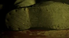 Cinematic shot of man's shoes with full of blood lying on the floor